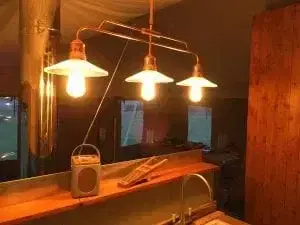 3 overhead lights lighting up the kitchen in a safari tent