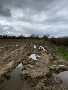 A muddy field with puddles