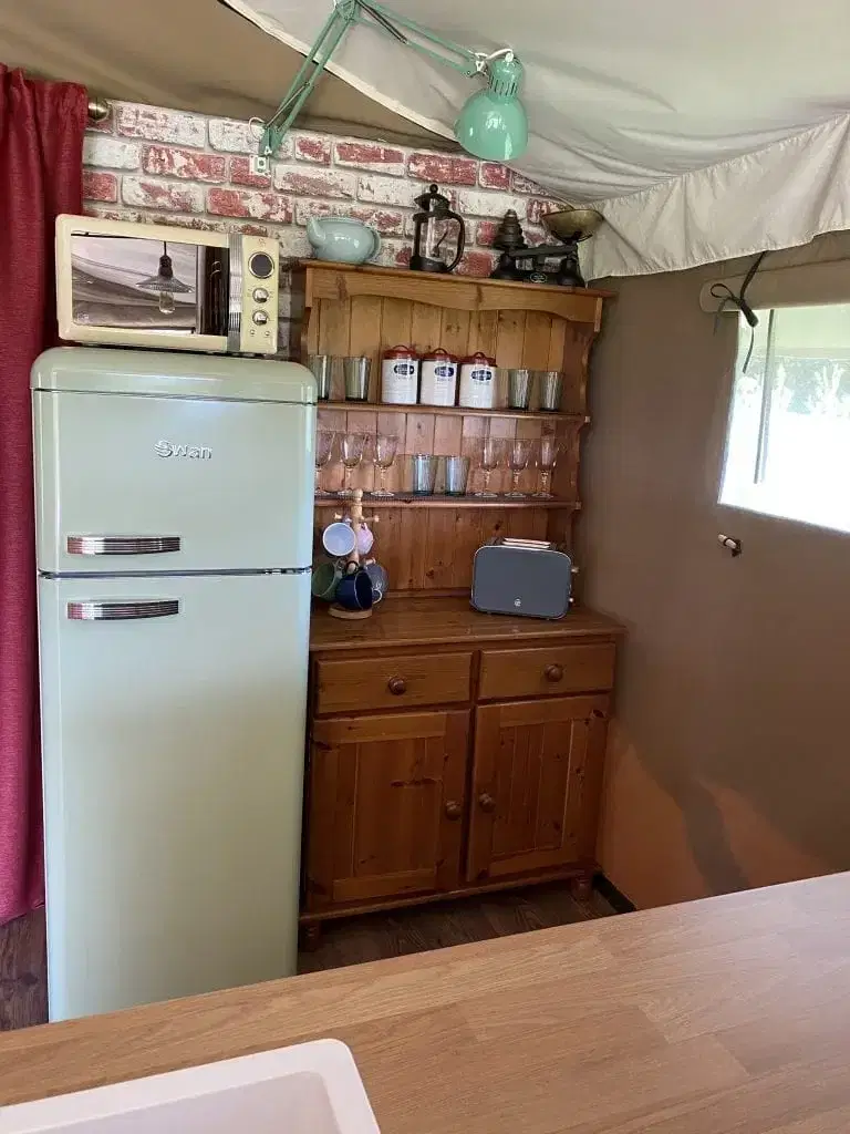 Safari tent kitchen with fridge wooden cabinet and sink