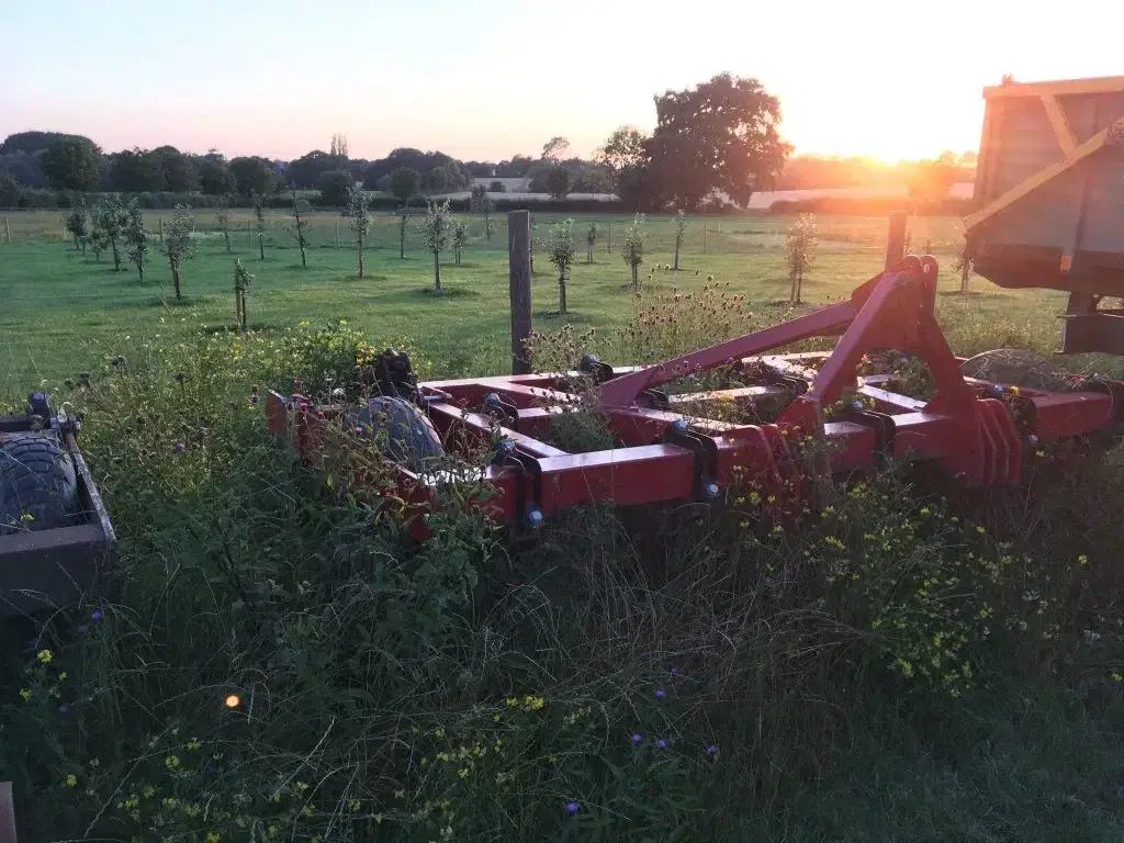 Farm machinery next to an orchard