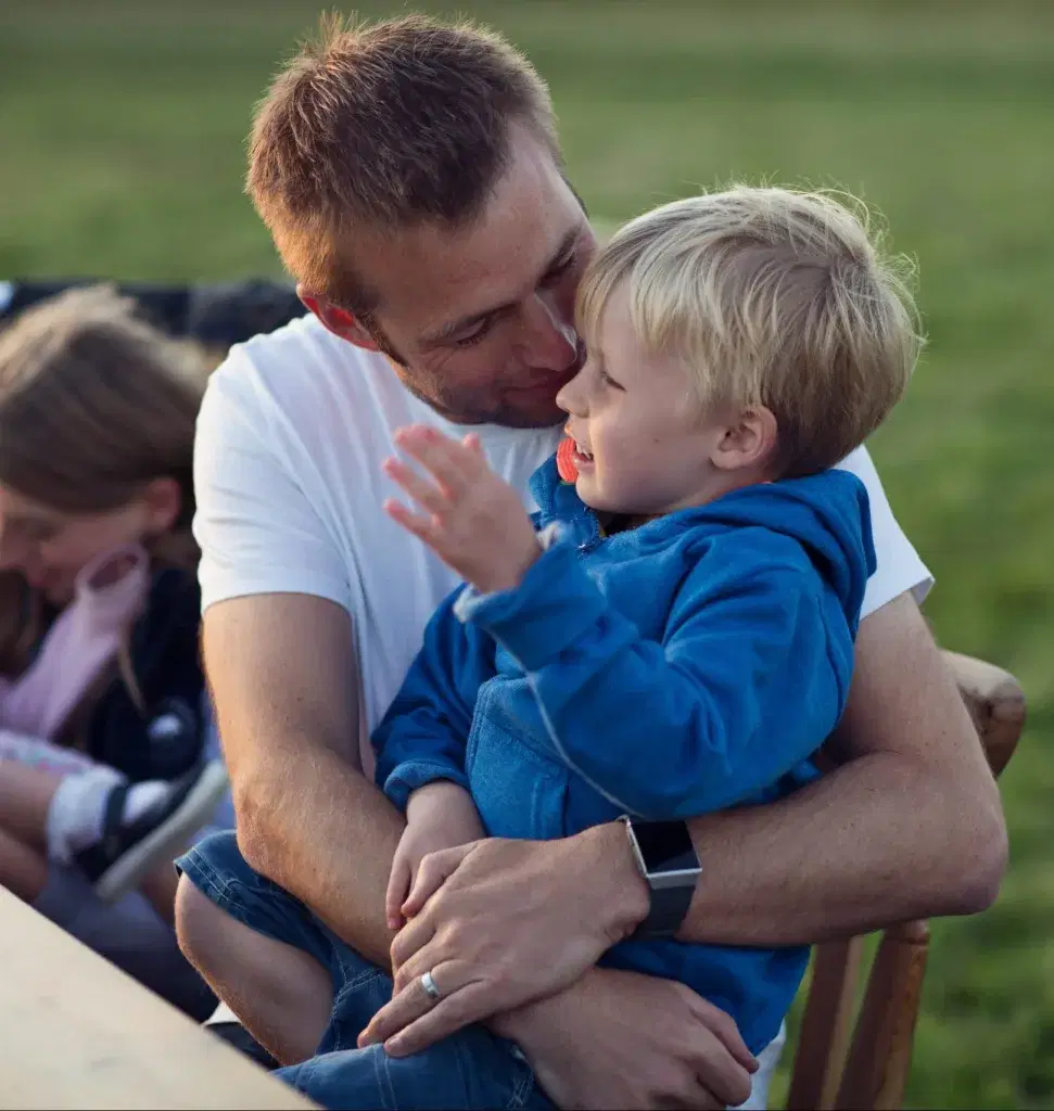 father with son in his lap looking happy