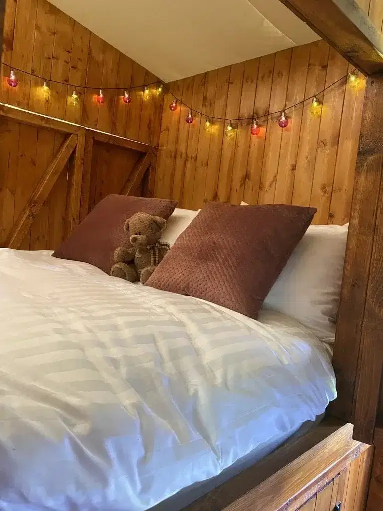 Fairy lighting in a wooden double camp bed