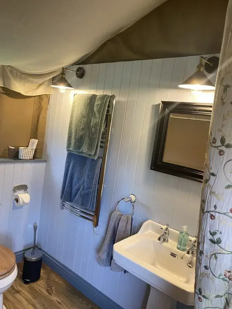 wooden panelled sink and toilet area with towels
