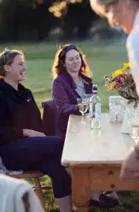 people laughing at a table outside