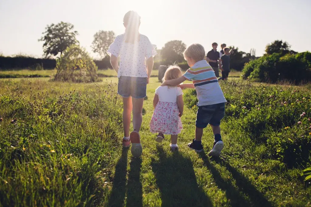 children exploring in a field on a sunny day