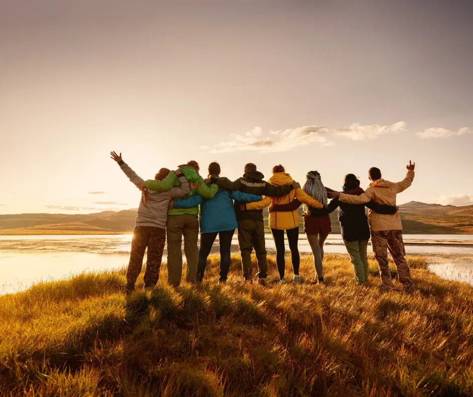 Friends gathered around a fire pit at Meadow Field, building the power of annual traditions