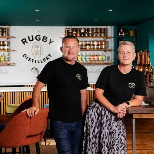 Owners standing inside Rugby Distillery school